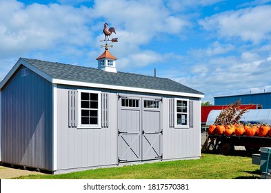 American Style Wooded Shed, Grey. A Shed Is Typically A Simple, Single-story Roofed Structure In A Back Garden Or On An Allotment That Is Used For Storage, Hobbies, Or As A Workshop. Exterior View