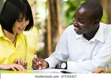 American Teacher Teaching Asian Student About Foreign Languages.