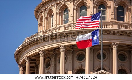 American and Texas state flags flying on the dome of the Texas State Capitol building in Austin