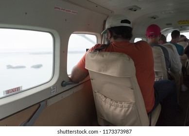 American Tourists On Belize Corporate Retreat Fly In A Small Plane With A View Of The Caribbean