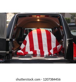 American Veteran's Flag Draped Casket In A Hearse, Ready For Transport To His Final Resting Place.