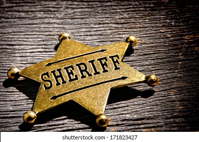 American West Legend Law Enforcement Officer Antique Sheriff Deputy Star Shape Gold Color Brass Badge As Vintage Western Lawman Identification And Prestige Shield On Old Frontier Jail Office Table