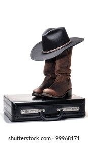 American Western Texas style business with black cowboy hat atop traditional brown leather boots on a businessman briefcase over white
