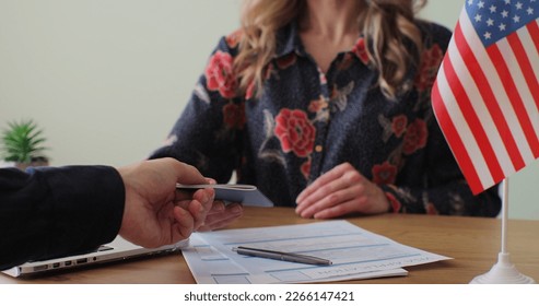 American woman consular officer giving passport to male immigrant, work visa, citizenship. Visa Application online form immigration concept. Visa approval. - Shutterstock ID 2266147421