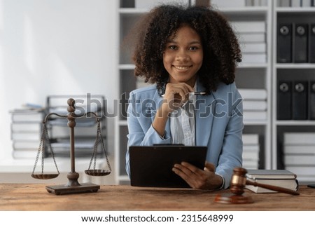 American woman lawyer or businesswoman African working with laptop, searching, analyzing data, reading contract documents work with law books hammer of justice Consulting lawyer concept.