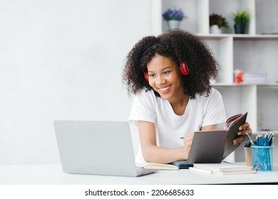 American Woman In White Room, She Is A College Student, She Is Studying Online At Her Home, She Is Studying Via Video Calling On Her Laptop And Doing Homework. The Concept Of Students Studying Online.