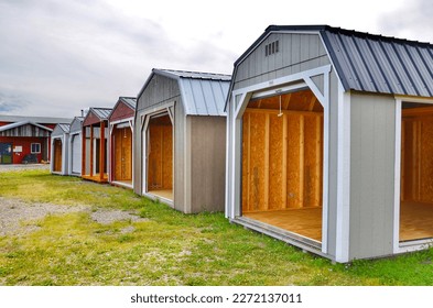  American wooden sheds with metal roof and garage sliding door style in display. Simple single-story roofed structure in a backyard or on an allotment that is used for storage, hobbies, or workshop. 