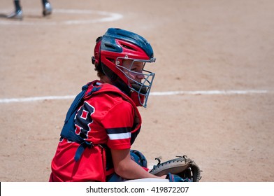 American Youth Baseball Catcher Looking At Coach For Signals.