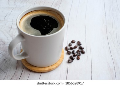 Americano With Coffee Beans On Wood Texture Background