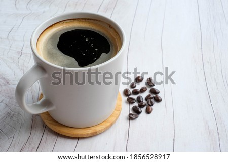 americano with Coffee beans on wood texture background