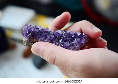 Amethyst crystal cluster being held in woman's hand, lush purple healing crystal cluster. Macro photo in natural lighting, deep purple healing crystal. Natural minerals, crisp colors. 