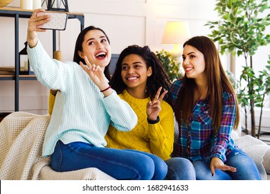 Amiable multiracial girls live streaming from home using smartphone - Shutterstock ID 1682941633