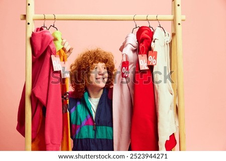 Amidst vibrant array of sale-tagged outfits, happy shopper beams with excitement, making most of markdowns on stylish finds. Concept of Black Friday, Cyber Monday, fashion, Flash Sale. Ad