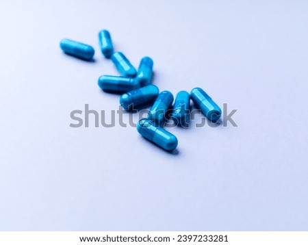 Amino acids capsules on bright paper background. Soft focus. Close up. Copy space. 