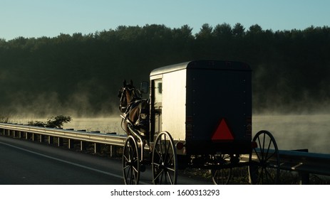 Amish Buggy Crossing Bridge Over Misty Lake