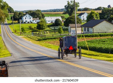 Amish Buggy Goes Down Road In Rural Pennsylvania.