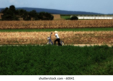 AMish Child On A Scooter WIth Blur And Color Effect.