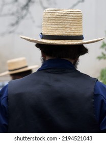 An Amish Man Wearing A Straw Hat From Behind