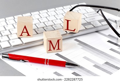 AML written on a wooden cube on the keyboard with chart on a grey background - Shutterstock ID 2282287725