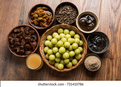 Amla/Indian Gooseberry and it's by products like Chyawanprash, Juice, Digestive Supari or Mouth Freshner, Powder, Sweet Murabba, Pickle. Over moody background. selective focus