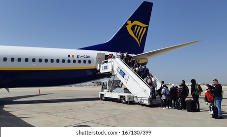 Amman, Jordan, March 2020: People Boarding A Ryanair Flight At The Back Entrance Of The Airplane On The Airport Tarmac Via Stairs Entrance