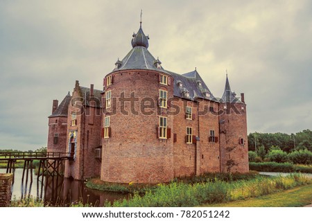 Ammersoyen Castle with its brick towers, wooden bridge, water filled moat and gardens on cloudy day. Near to the historic and vibrant city of s-Hertogenbosch. Southern Netherlands. Retro vintage filte
