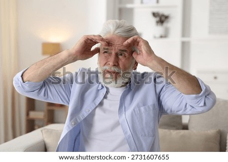Amnesia. Senior man trying to remember something at home