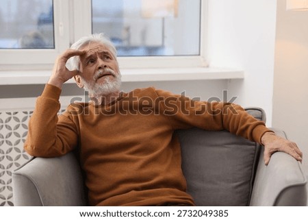 Amnesia. Senior man trying to remember something at home