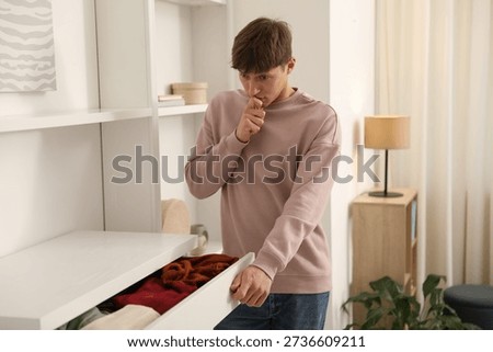 Amnesia. Thoughtful man trying to remember something near open drawer at home