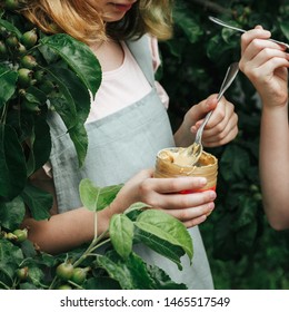 Among The Branches Of The Apple Tree Children's Hands With A Jar Of Peanut Butter.