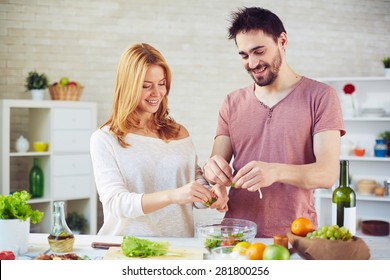 Amorous Young Couple Cooking Salad Together