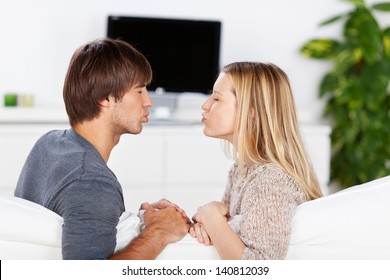 Amorous Young Couple Kissing On The Sofa