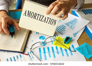 Amortization concept. Notepad in the hands of an accountant.