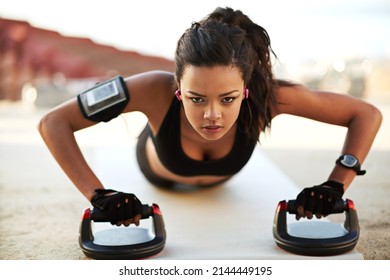 Amp Up Your Pushup. Shot Of A Young Woman Exercising Using Push Up Grips.