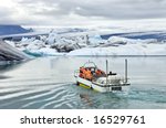 An amphibious vehicle taking tourists for a cruise around the icebergs in the Jokulsarlon glacier lake, where huge chunks of ice from the Vatnajokull glacier float out to the Atlantic ocean