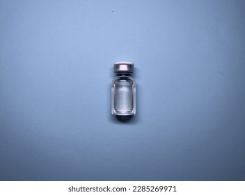 Ampoule on a gray background, with liquid inside. Containing a drug or preparation for medicine, aesthetic medicine, mesotherapy treatments, mesococktail. One vial, ampule