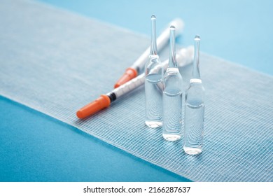 Ampules And Syringes On Steile Bandage Surface. Close Up Image Of Medical Supplies.