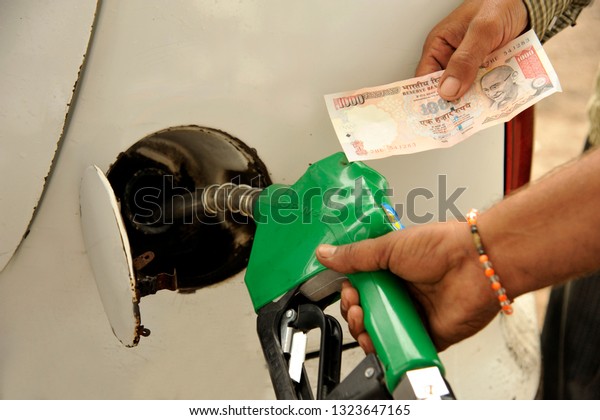 Amreli\
Gujarat india  Sep. 29 2009  A fuel station customer holding one\
thousand rupees note showing inflammation or high raise of Petrol\
and disel prices have hiked for last few\
days