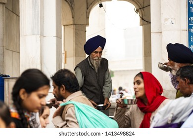AMRITSAR - PUNJAB - INDIA - 13 NOVEMBER 2017. A Sikh man is serving  food to pilgrims in the Golden Temple in Amritsar, Punjab, India. The Golden Temple is the holiest shrine of the Sikh religion.