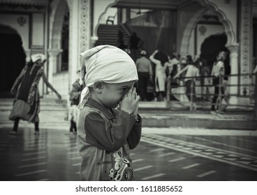 Amritsar, Punjab/ India - January 10 2020:  Beautiful Selective Focused View Of Indian Kid Praying In Gurudwara Sahib