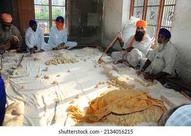 Amritsar, Punjab, India-Sep 13 2009: Sikh Man And Indian Woman Prepare Chapati - Traditional Indian Bread At The Golden Temple (sri Harmandir Sahib)