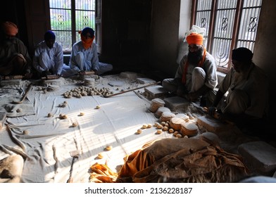 Amritsar, Punjab, India-Sep 13 2009: Sikh Man And Indian Woman Prepare Chapati - Traditional Indian Bread At The Golden Temple (sri Harmandir Sahib)