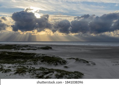 Amrum island, Germany: sun rays emerging through the dark storm clouds at the beach of Amrum. Sunset is obscured by a thick cloud front announcing bad weather - Shutterstock ID 1841038396