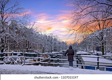 Amsterdam covered with snow  in winter in the Netherlands at sunset
