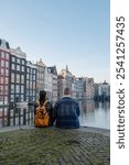 Amsterdam Damrak during sunset, happy couple man and woman on a winter evening at the canals Amsterdam at winter