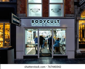 Amsterdam, December 2017. Outside view of a tattoo and piercing shop, with several customers inside