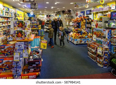 Amsterdam, February 2017. A Mother And Two Young Kids Inside A Toy Shop Of The Intertoys Chain