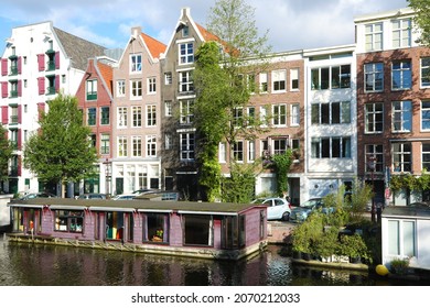 Amsterdam, Holland - October 16, 2021: Floating house docked on canal in Amsterdam