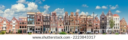 Amsterdam  Long Panorama of famous Amsterdam houses with blue sky. Various traditional houses in the historic center of Amsterdam. Amsterdam, Holland, Netherlands, Europe