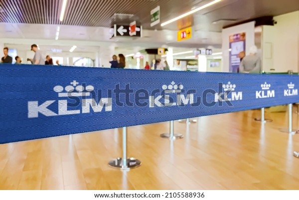 Amsterdam, NED, July 2019:\
blue belt barrier with the KLM airlines logo. KLM Royal Dutch\
Airlines is the flag carrier airline of the Netherlands. Selective\
focus